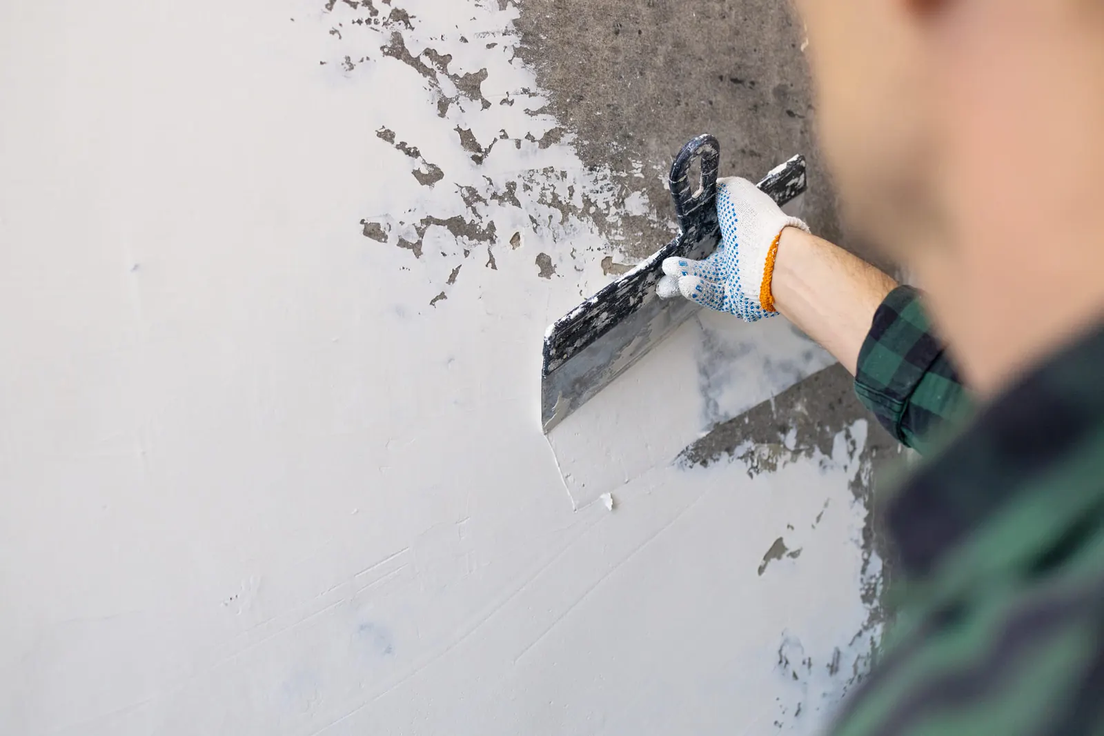 Artisan lissant un mur à la spatule